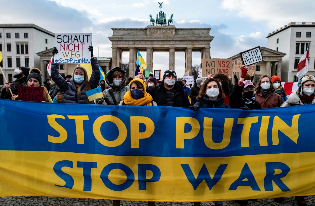 متظاهرون يحملون لافتة بألوان العلم الأوكراني كُتب عليها بالانكليزية "أوقفوا بوتين أوقفوا الحرب" في تظاهرة في برلين في 30 كانون الثاني/يناير 2022 (أ ف ب)