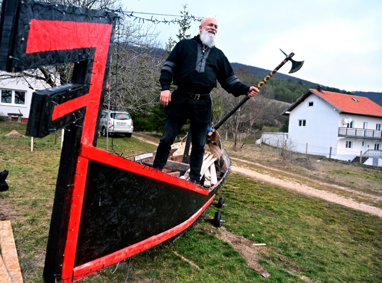 ستبيه بليتس يحمل فأساً ويقف على قارب فايكنغ صنعه بنفسه في توميسلافغراد بالبوسنة في 5 كانون الثاني/يناير 2022 (ا ف ب)