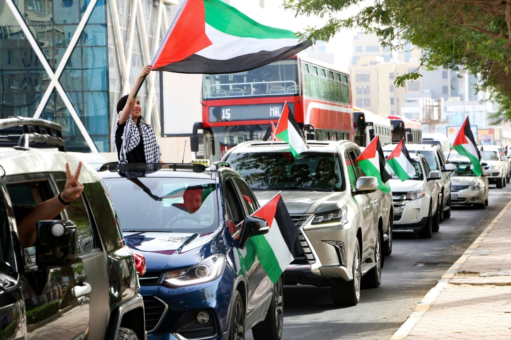 كويتيون يلوّحون بالعلم الفلسطيني خلال مسيرة للتضامن مع الفلسطينيين في العاصمة في 15 أيار/مايو 2021(ا ف ب)
