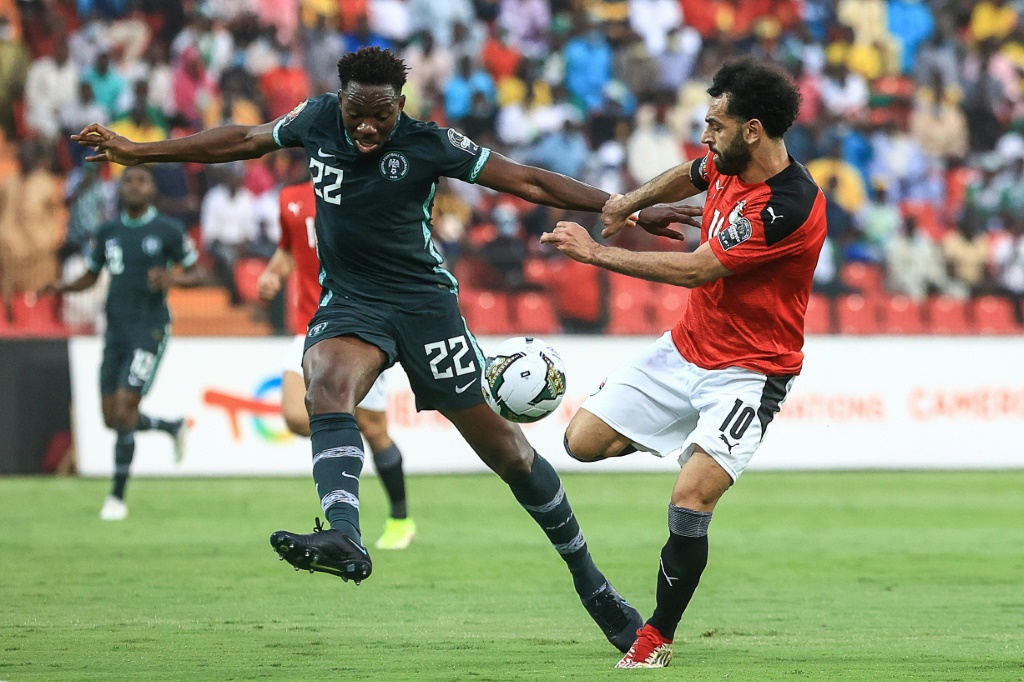 نجم منتخب مصر محمد صلاح (يمين) في صراع على الكرة مع مدافع نيجيريا كينيث اميروو خلال لقاء الفريقين في كأس الأمم الأفريقية 11 يناير 2022 (ا ف ب)