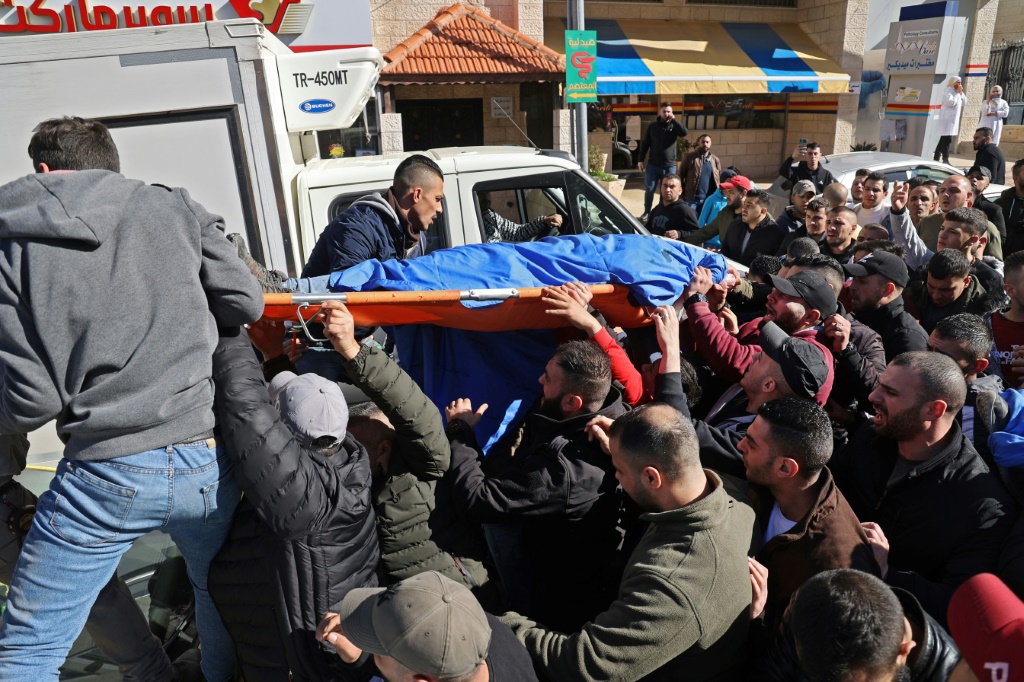 فلسطينيون يحملون جثة فلسطيني قتل مع اثنين آخرين برصاص الجيش الإسرائيلي في الثامن من شباط/فبراير 2022 في مدينة نابلس في الضغة الغربية المحتلة (أ ف ب)
