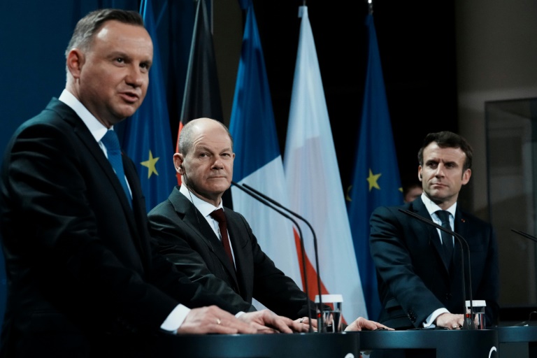 المستشار الألماني اولاف شولتس (وسط) إلى جانب الرئيس البولندي أندريه دودا (يسار) والفرنسي إيمانويل ماكرون في برلين بتاريخ 8 شباط/فبراير 2022  (ا ف ب)