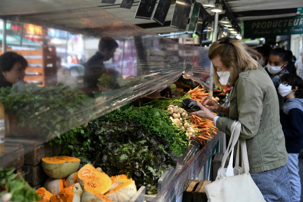 سيدة تشتري الخضار والفاكهة في سوق في باريس في 12 أيار/مايو 2020(ا ف ب)