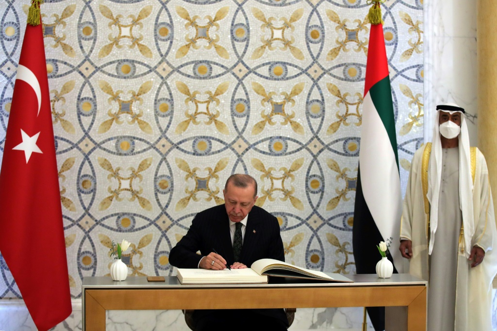  الرئيس التركي رجب طيب اردوغان يتكب رسالة في كتاب الزوار في قصر الوطن في أبوظبي في 14 شباط/فبراير 2022 (أ ف ب) 