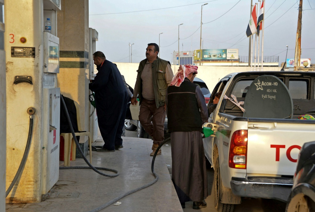 عراقيون أمام محطة وقود في مدينة الموصل في شمال العراق ينتظرون دورهم لتعبئة سياراتهم من مادة البنزين الخميس 17 شباط/فبراير 2022(ا ف ب)