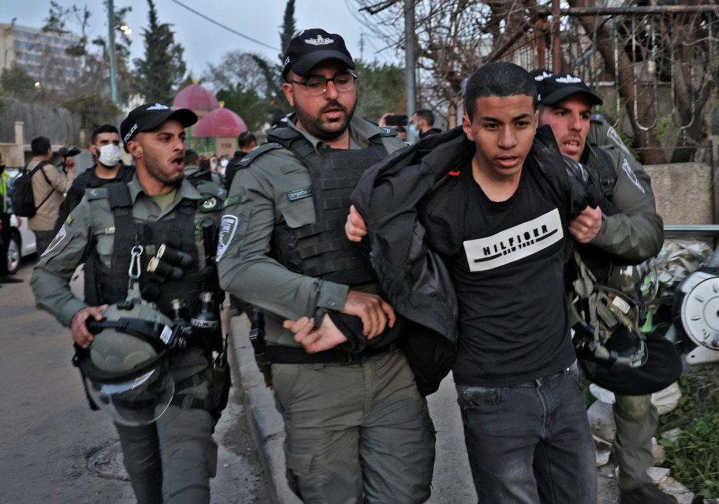 عناصر من الشرطة الإسرائيلية يعتقلون متظاهراً ضدّ طرد عائلات فلسطينية من مساكنها في حي الشيخ جراح في القدس الشرقية في 18 شباط/فبراير 2022.(ا ف ب)