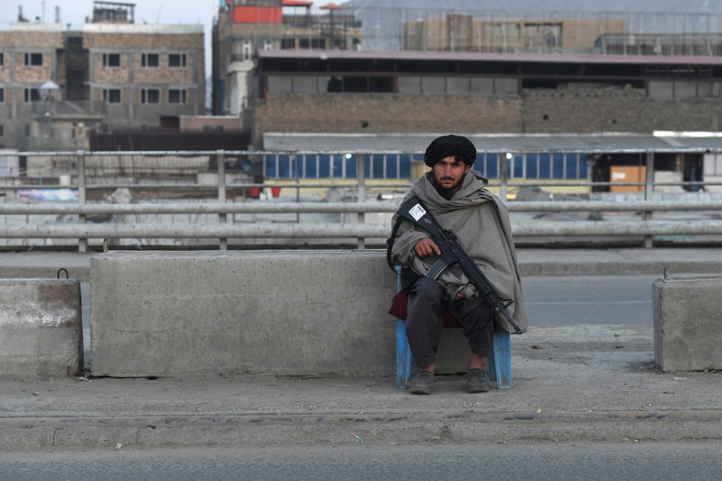 مقاتل من طالبان يحرس نقطة تفتيش على طريق في كابول (أ ف ب)