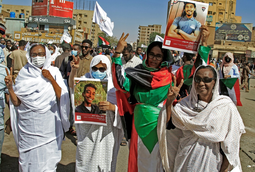 متظاهرون في الخرطوم بحري يحملون صورا لمحتجين قتلوا في مظاهرات سابقة خلال مسيرة للمطالبة بحكم مدني (أ ف ب)
