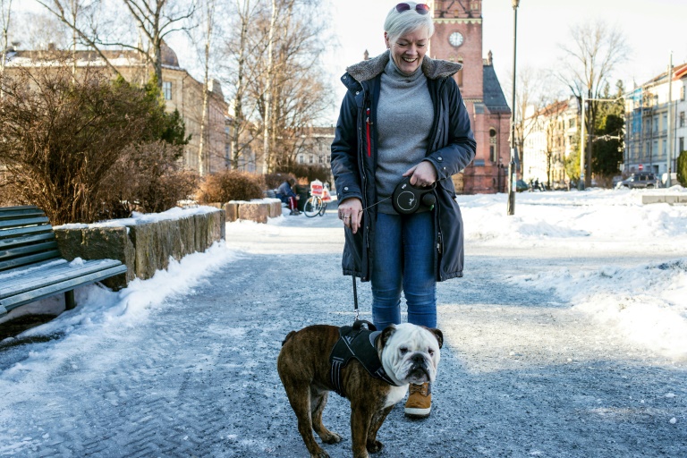 آن غريث هولن تنزّه كلبها أوسكار في العاصمة النروجية أوسلو في 7 شباط/فبراير 2022 (ا ف ب)