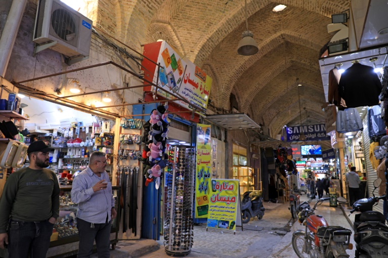  عراقيون في سوق في مدينة العمارة في محافظة ميسان في جنوب شرق العراق بتاريخ 16 شباط/فبراير 2022 (أ ف ب)