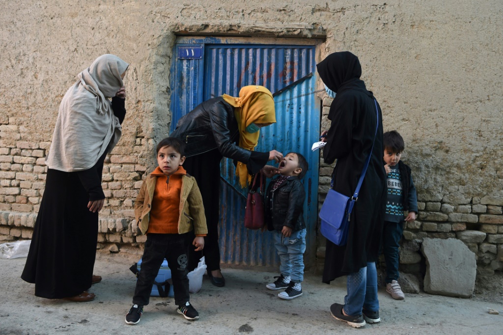 عامل صحي يعطي لقاح شلل الأطفال لطفل في الربع القديم من كابول في نوفمبر 2021 ، بعد وقت قصير من إعلان طالبان أنها ستعمل مع الأمم المتحدة في حملة للقضاء على الفيروس (أ ف ب)   