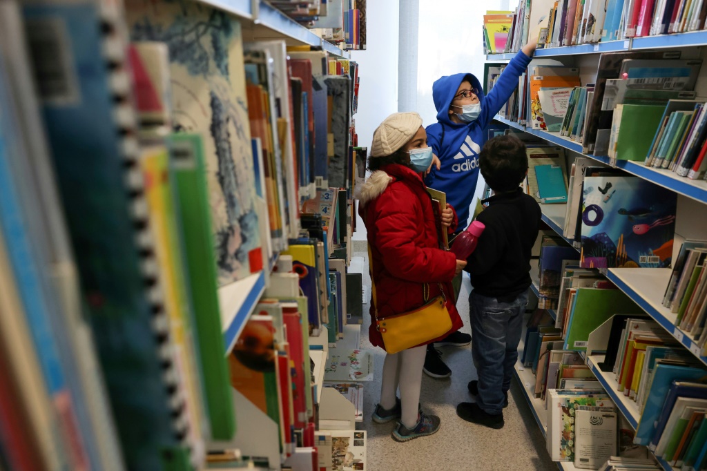 أطفال يختارون كتباً لاستعارتها مجاناً من المكتبة العامة لبلدية بيروت في الباشورة في 11 شباط/فبراير 2022 بعدما بات شراء الكتب الجديدة مكلفاً على وقع الانهيار الاقتصادي (ا ف ب)
