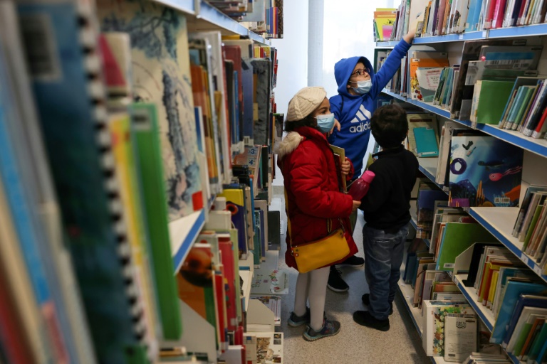أطفال يختارون كتباً لاستعارتها مجاناً من المكتبة العامة لبلدية بيروت في الباشورة في 11 شباط/فبراير 2022 بعدما بات شراء الكتب الجديدة مكلفاً على وقع الانهيار الاقتصادي (ا ف ب)