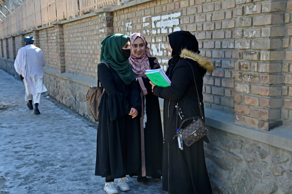 تدردش الطالبات بالقرب من جامعة كابول بعد انتهاء الدراسة عندما أعادت المؤسسة فتح أبوابها (أ ف ب)