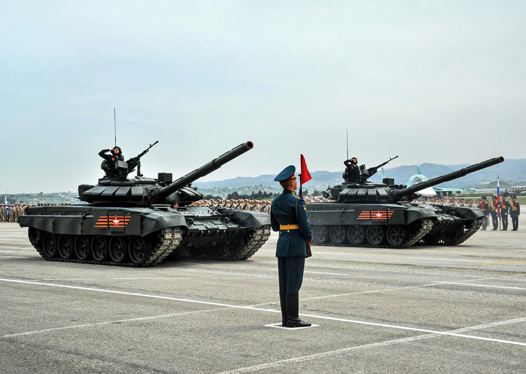 &nbsp;  صورة منشورة من عرب نيوز تظهر جندي روسي يقف بجانب دبابات T-90 خلال العرض العسكري يوم النصر ، في أيار 2021 ، في قاعدة حميميم العسكرية الروسية ، جنوب شرق ميناء اللاذقية السوري (أ ف ب)
