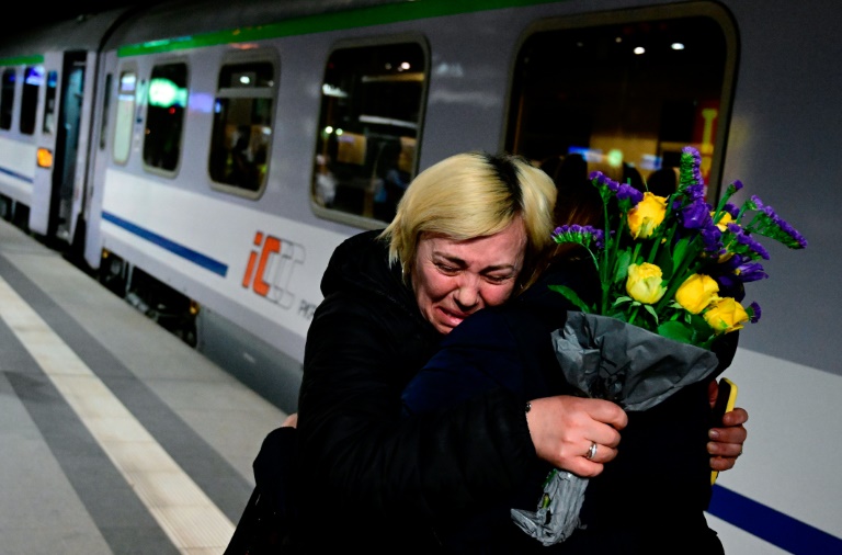 امرأة تشعر بالارتياح من قبل صديق لها بعد وصولها على متن قطار من الحدود الأوكرانية في محطة القطار الرئيسية في برلين في مارس 2, 2022(أ ف ب)