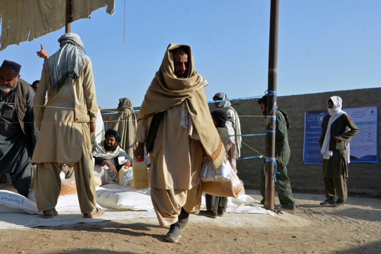 افغاني يحمل موادا غذائية وزعها أفراد في برنامج الغذاء العالمي للعائلات المحتاجة في قندهار في 23 كانون الاول/ديسمبر 2021 (ا ف ب)