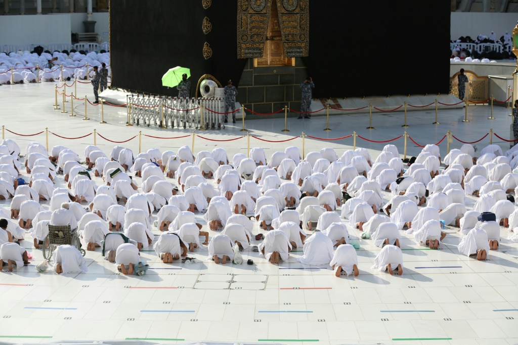 مسلمون يصلون في المسجد الحرام في مكة في 31 كانون الأول/ديسمبر 2021، في صفوف متباعدة التزاما باجراءات التباعد الاجتماعي التي أعيد فرضها مع تزايد إصابات فيروس كورونا.(ا ف ب)