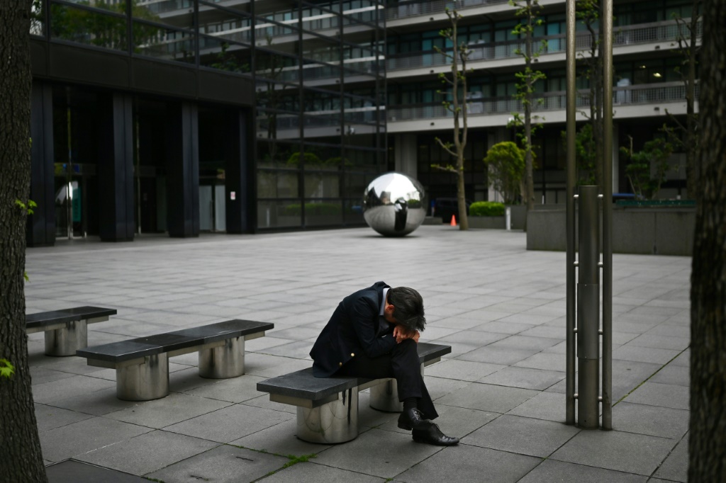 رجل يستريح على مقعد خلال استراحة الغداء في طوكيو في 21 نيسان/ابريل 2020(ا ف ب)