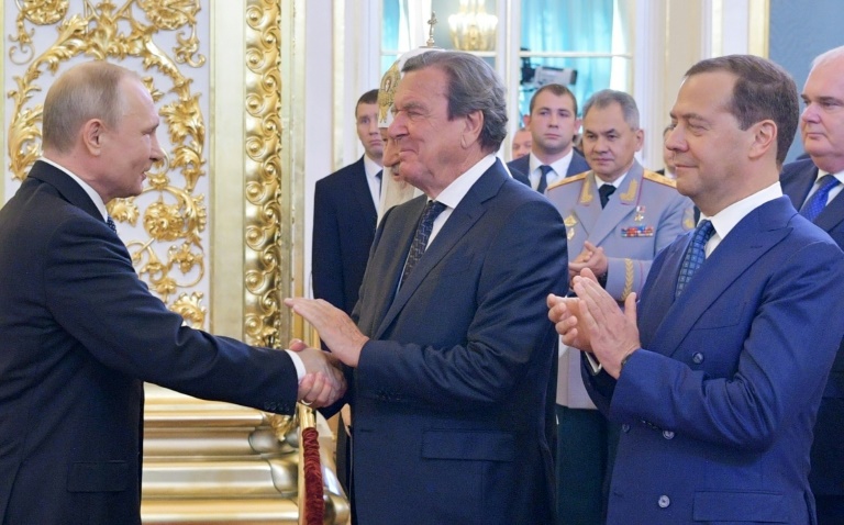 الرئيس الروسي فلاديمير بوتين يصافح المستشار الألماني السابق غيرهارد شرودر في الكرملين بتاريخ 7 أيار/مايو 2018 (ا ف ب)