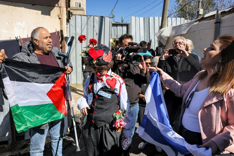 مواجهة بين رجل يحمل العلم الفلسطيني ومستوطنة تحمل العلم الإسرائيلي في حي الشيخ جراح في القدس الشرقية المحتلة في 13 شباط/فبراير 2022 (ا ف ب)