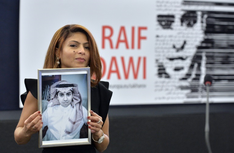 إنصاف حيدر تحمل صورة لزوجها المدوّن السعودي رائف بدوي في ستراسبورغ في فرنسا في 16 كانون الأول/ديسمبر 2015 (ا ف ب)