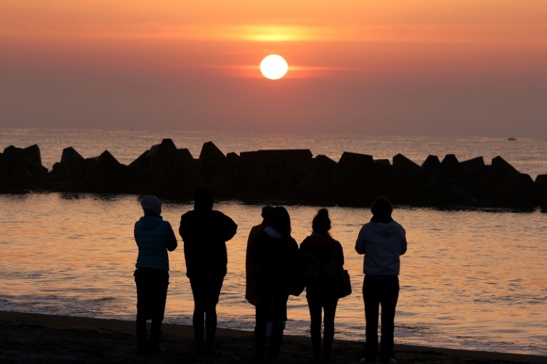 أشخاص يُصلّون عند الفجر قرب المحيط الهادئ في سينداي (شمال شرق اليابان) بالذكرى الـ11 للكارثة النووية في فوكوشيما (ا ف ب)
