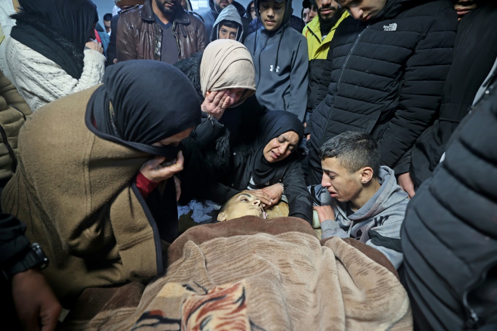 أقارب الفتى الفلسطيني نادر ريان أمام جثته في مستشفى في نابلس بتاريخ 15 آذار/مارس 2022 (أ ف ب)