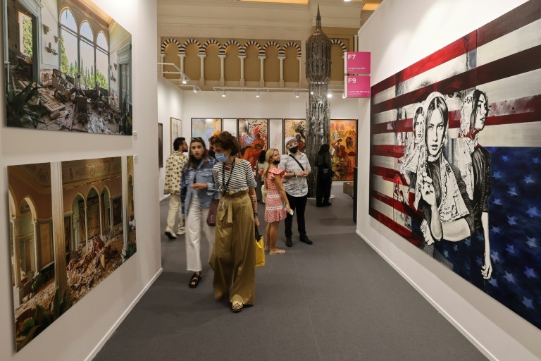زوار في معرض "آرت دبي" أمام أعمال في دبي في 10 آذار/مارس 2022 (ا ف ب)