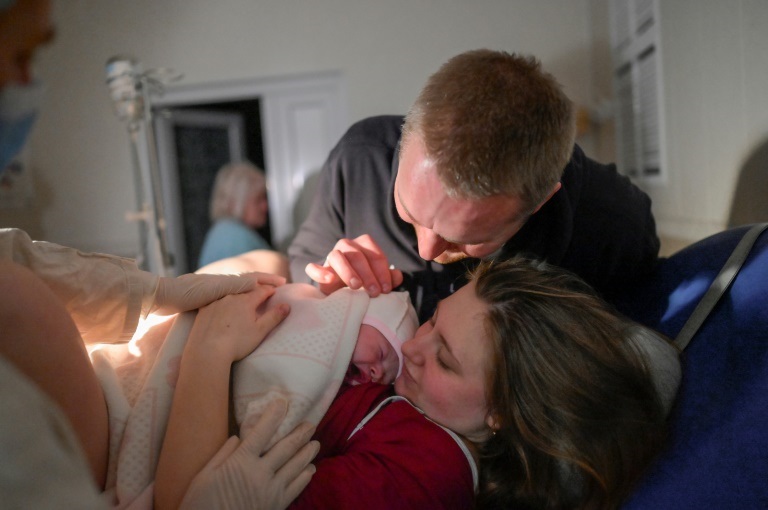 ألينا وزوجها يضمّان مولودتهما سنيجانا في غرفة الولادة في مستشفى تحت القصف الروسي في ميكولايف الأوكرانية في 14 آذار/مارس 2022 (ا ف ب)
