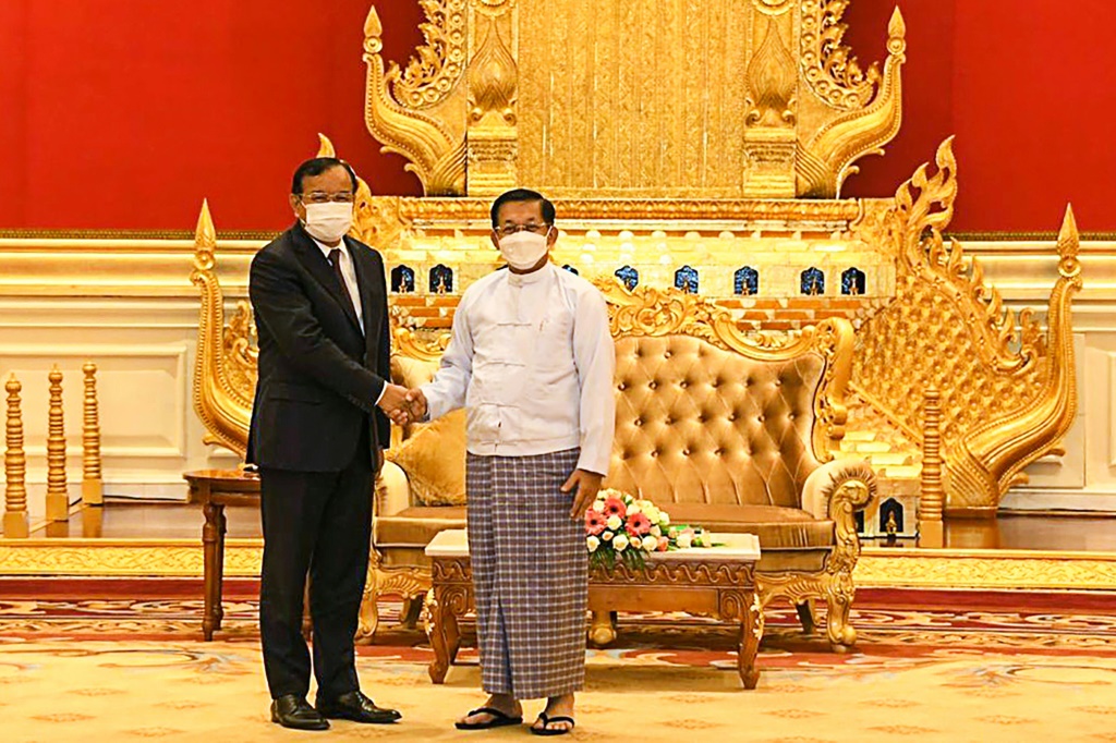    رئيس المجلس العسكري في ميانمار مين أونج هلاينج (يمين) يصافح وزير الخارجية الكمبودي براك سوكون يوم الاثنين (أ ف ب)