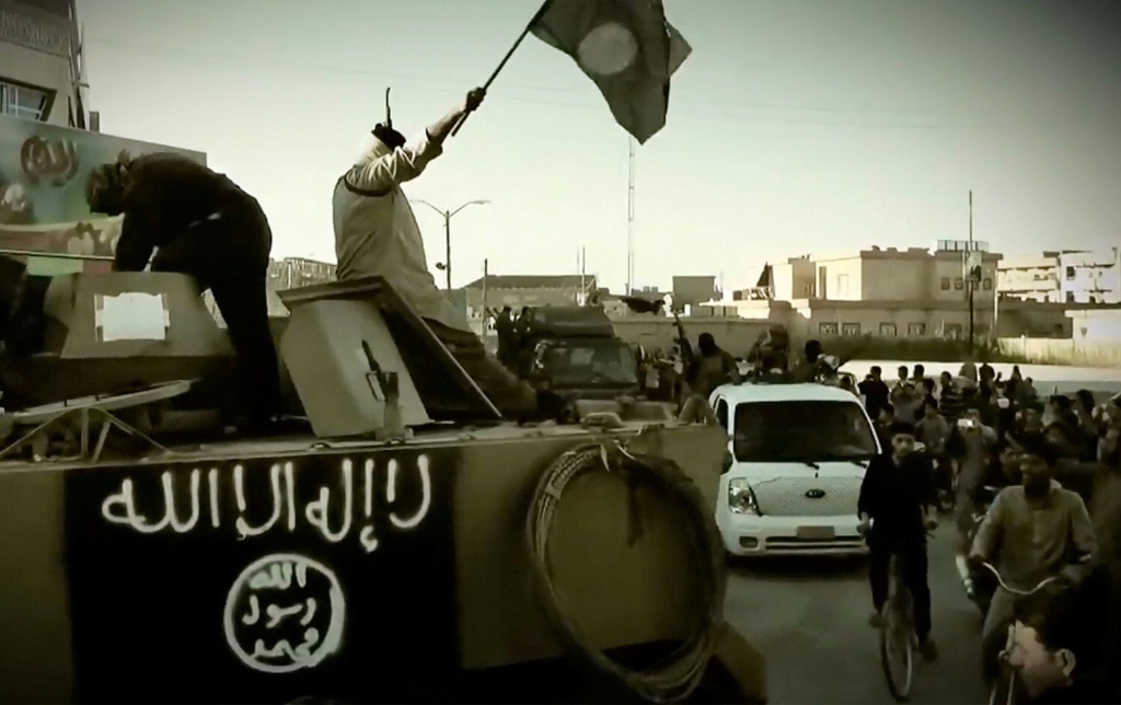 فيديو دعائي صدر في 17 مارس 2014 من قبل الجماعة التي كانت تسمى آنذاك الدولة الإسلامية في العراق والشام (داعش) تظهر مقاتلين على عربة مدرعة (أ ف ب) 