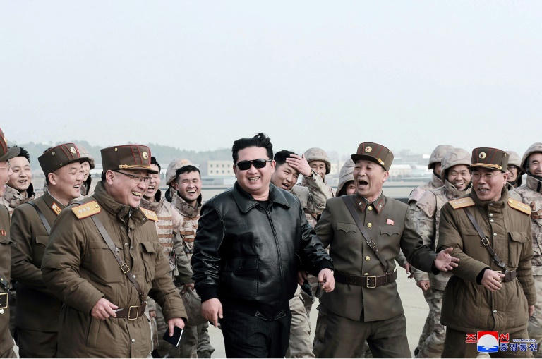  صورة مؤرخة في 25 آذار/مارس 2022 وزعتها وكالة الانباء الرسمية للزعيم الكوري الشمالي محاطا بعسكريين خلال تجربة لصاروخ بالستي عابر للقارات (ا ف ب)