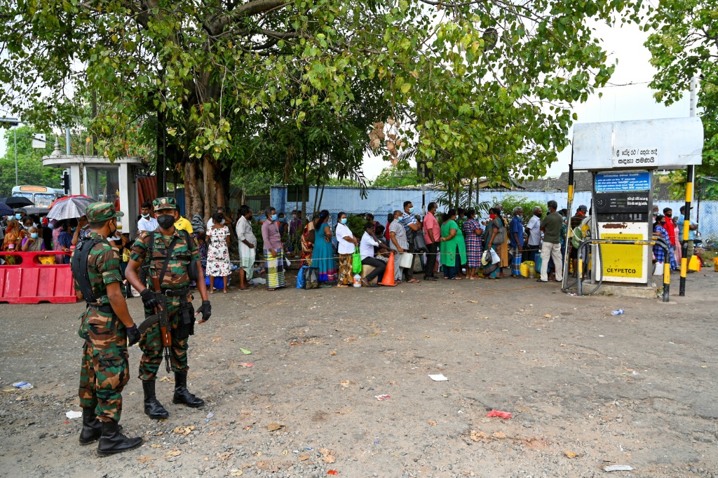 جنود يحرسون محطة خدمة حيث ينتظر الناس الحصول على الوقود في كولومبو بينما تكافح سريلانكا مع أسوأ انهيار اقتصادي لها منذ أكثر من سبعة عقود (أ ف ب)