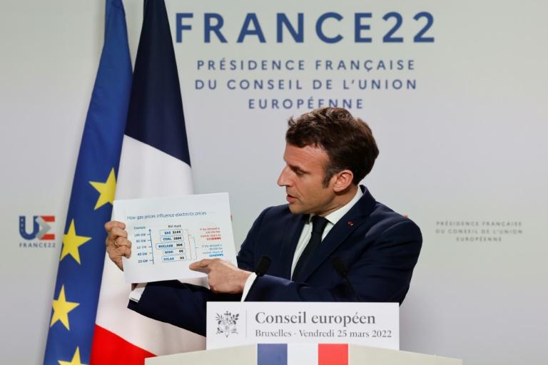 الرئيس الفرنسي إيمانويل ماكرون يعرض رسما حول كيفية تأثير أسعار الغاز على أسعار الكهرباء أثناء حديثه إلى الصحافة في اليوم الثاني من قمة الاتحاد الأوروبي في مقره في بروكسل بتاريخ 25 آذار/مارس 2022 (ا ف ب)