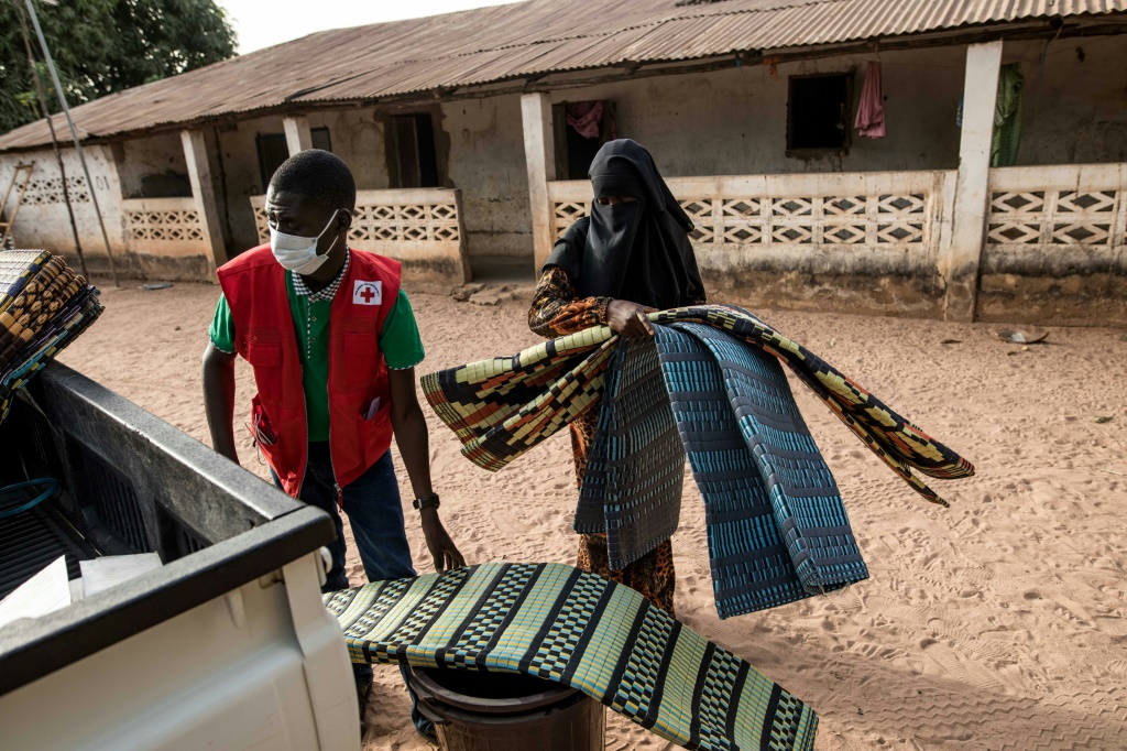 ناشطون في جمعية الصليب الأحمر الغامبية يقدمون مساعدات عاجلة لنازحين من إقليم كازامانس السنغالي، في قرية سابينور في غامبيا في 15 آذار/مارس 2022 (أ ف ب)  