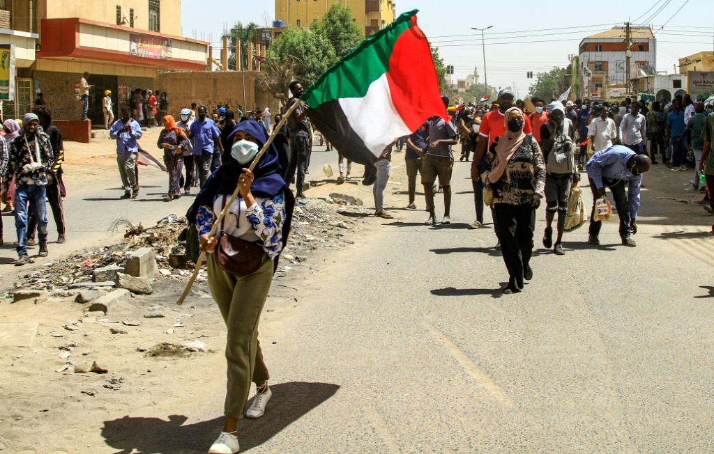 رفع العلم السوداني خلال تظاهرة في الخرطوم ضد الانقلاب في 31 اذار/مارس 2022 (أ ف ب)