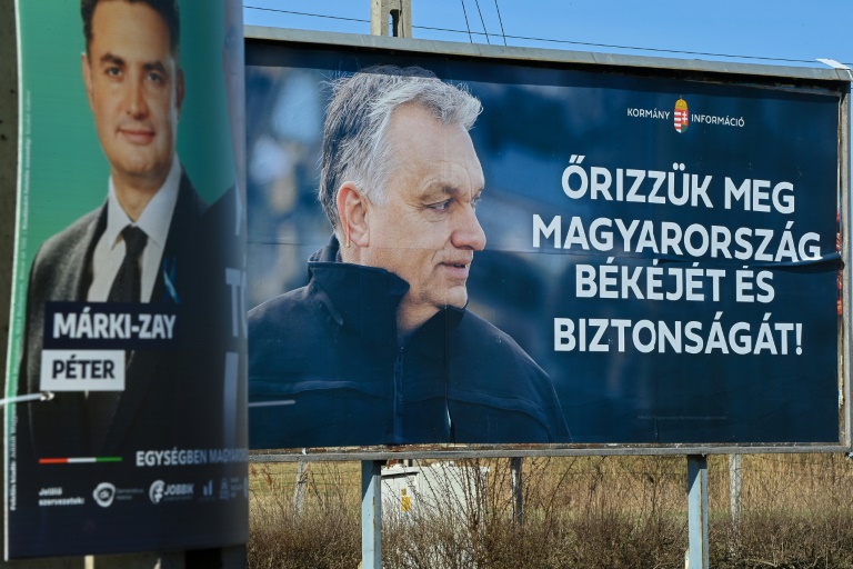 لافتة انتخابية ضخمة لرئيس الوزراء المجري فيكتور أوربان (يمين) كتب عليها "أنقذوا سلام المجر وأمنها"، بجانب لافتة أصغر حجما لخصمه بيتر ماركي زاي في بلدة كيسفاردا بشرق المجر في 28 آذار/مارس 2022(ا ف ب)