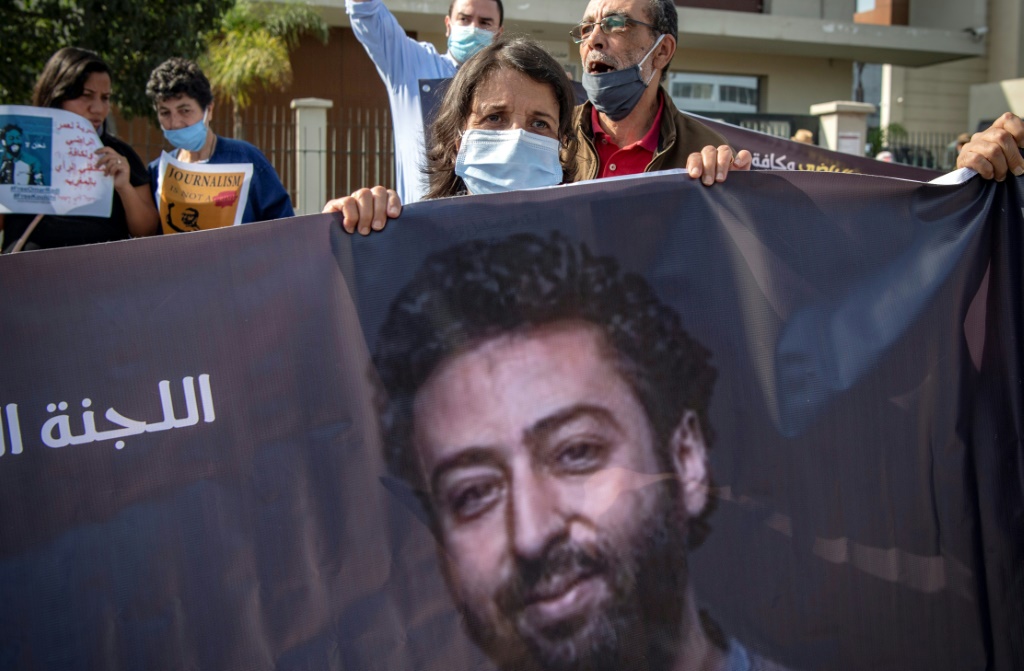 والدة الصحافي المغربي المحكوم عمر الراضي ترفع صورة له خلال تظاهرة تأييد في الدار البيضاء في ايلول/سبتمبر 2020 (أ ف ب)