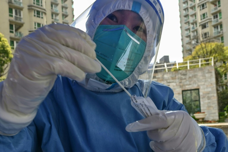عامل طبي يستعد لإجراء فحص لكشف الإصابة بكوفيد-19 في مجمع سكني في شانغهاي في الأول من نيسان/أبريل 2022 (ا ف ب )