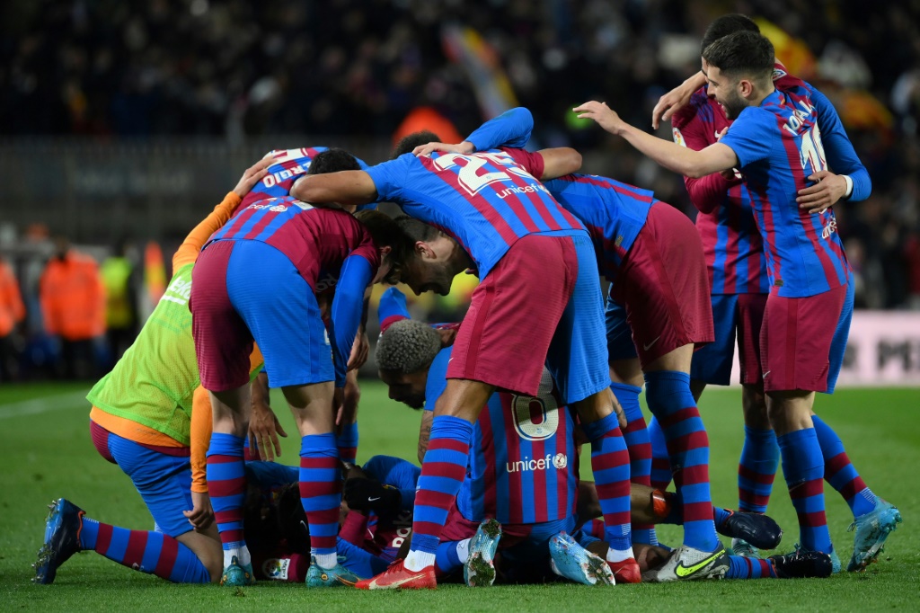 لاعبو برشلونة يحتفلون بهدف بيدري ضد إشبيلية في الدوري الاسباني لكرة القدم في ملعب كامب نو في 3 نيسان/ابريل 2022(ا ف ب)