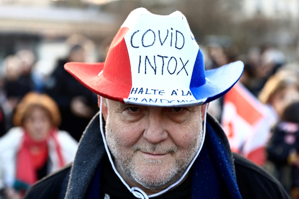محتج يعتمر قبعة بألوان العلم الفرنسي في تظاهرة في ساحة دانفير روشرو في جنوب باريس في 11 شباط/فبراير 2022 فيما يتوقع وصول قوافل محتجين على شهادة التلقيح إلى العاصمة الفرنسية (ا ف ب)