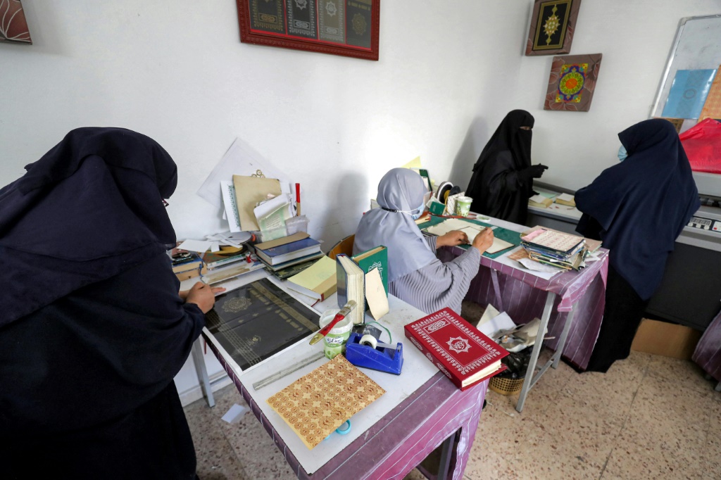 المشاركة النسائية في ورش ترميم المصاحف في ليبيا آخذة في الاتساع (أ ف ب)   