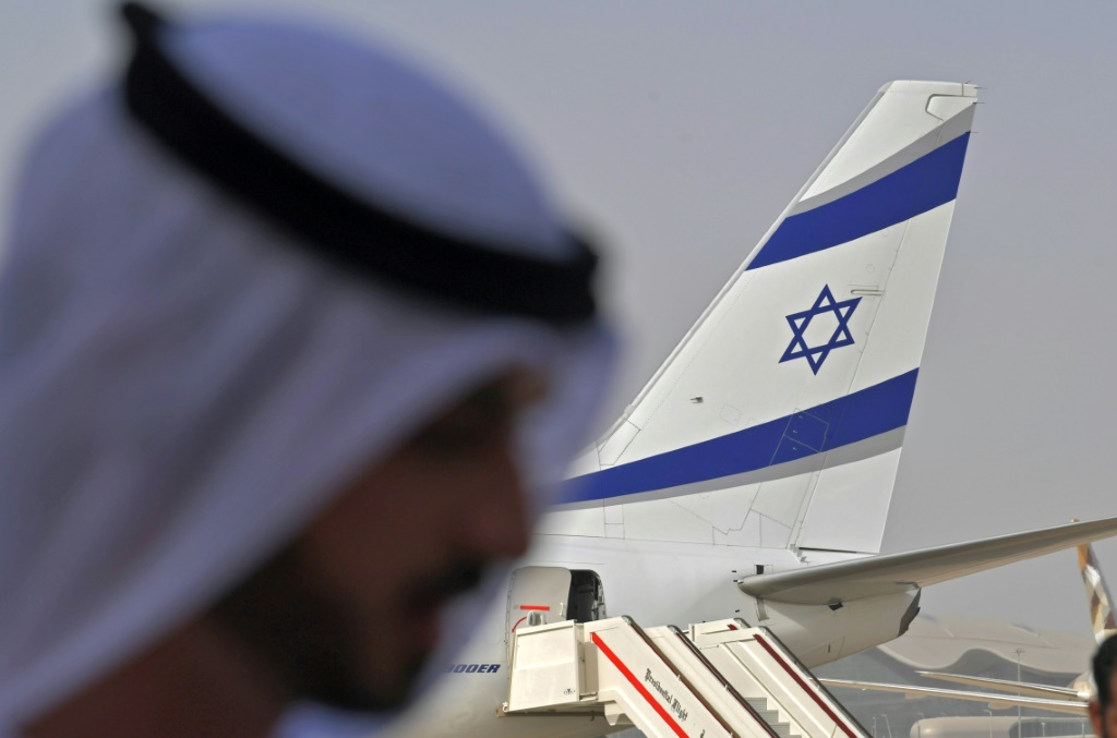 مسؤول إماراتي يقف قرب طائرة تابعة لشركة العال، في مطار أبوظبي في 31 آب/أغسطس 2020(ا ف ب)