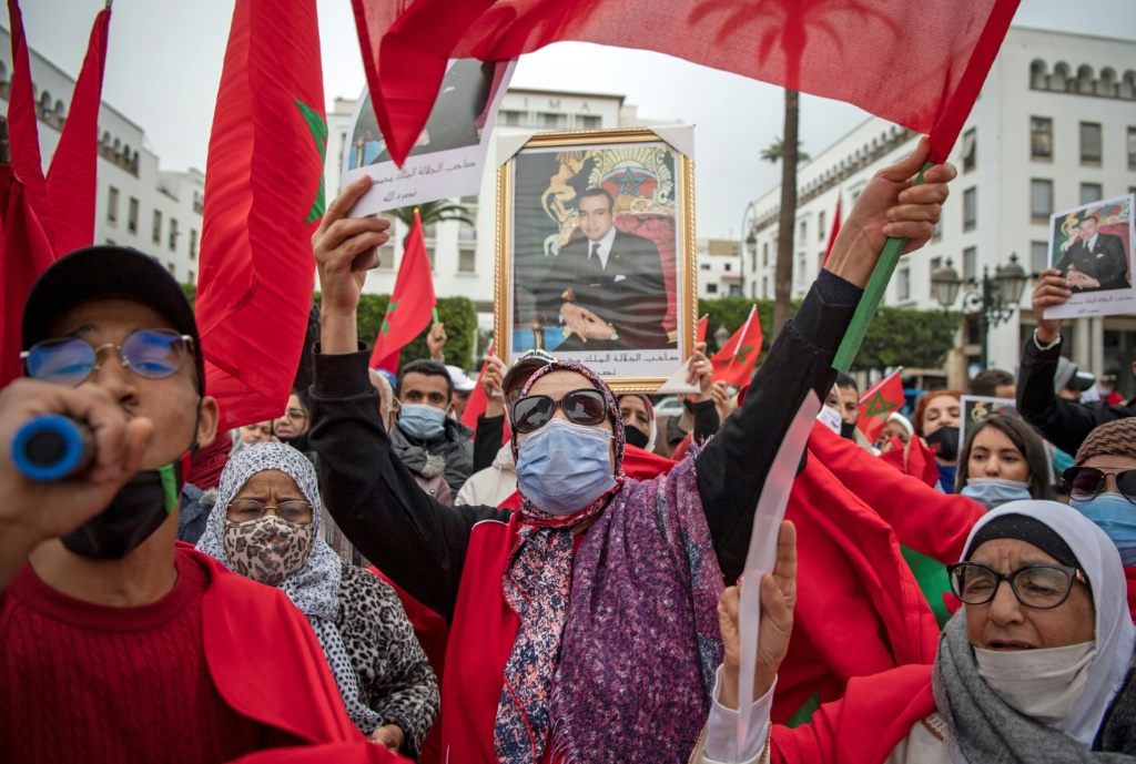 يحتفل المغاربة أمام مبنى البرلمان بالرباط في 13 ديسمبر 2020 ، بعد أن اعتمدت الولايات المتحدة خريطة رسمية جديدة للمغرب تشمل إقليم الصحراء الغربية المتنازع عليه (أ ف ب)