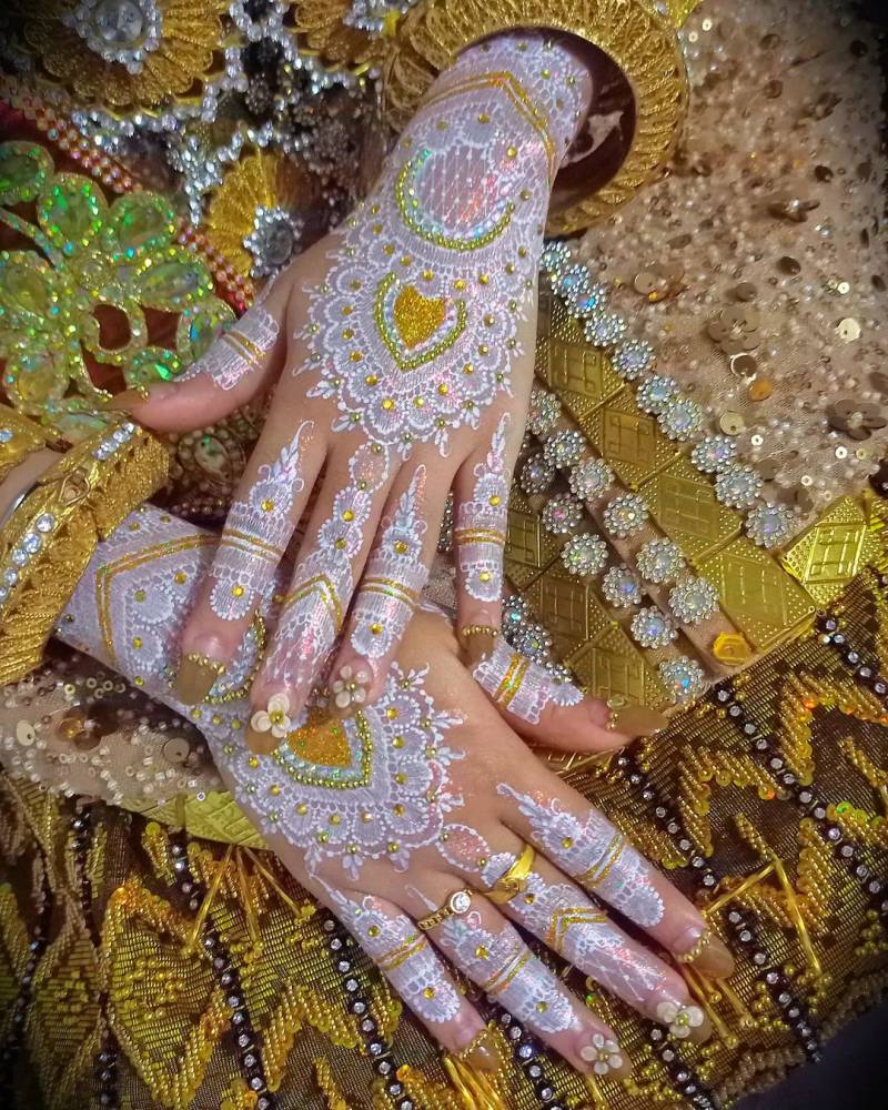نقش حناء بيضاء بالجليتر الملون للعروس الخليجية- الصورة من صفحة hennamakassargowa على إنستغرام