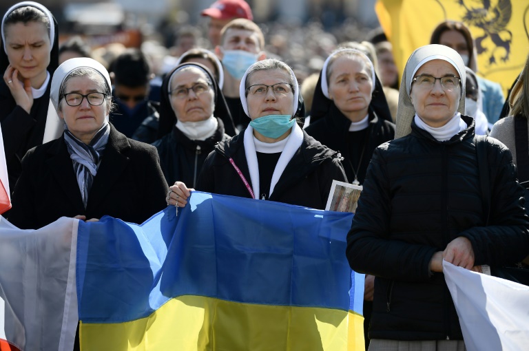 راهبات يرفعن علم أوكرانيا في ساحة القديس بطرس في الفاتيكان، في السادس من آذار/مارس 2022(ا ف ب)