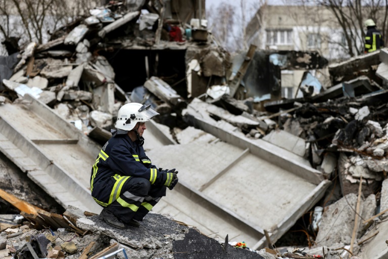  رجلا إطفاء اوكرانيان يحاولان إزالة أنقاض مبنى مدمر في مدينة بوروديانكا في شمال غرب أوكرانيا في 08 نيسان/ابريل 2022 (اف ب)