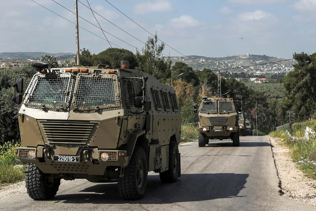  آليات عسكرية إسرائيلية تتحرك خلال تمر خلال مواجهات بين الجيش الإسرائيلي وفلسطينيين في مخيم جنين للاجئين الفلسطينيين شمال الضفة الغربية المحتلة في 9 نيسان/أبريل 2022 (ا ف ب)
