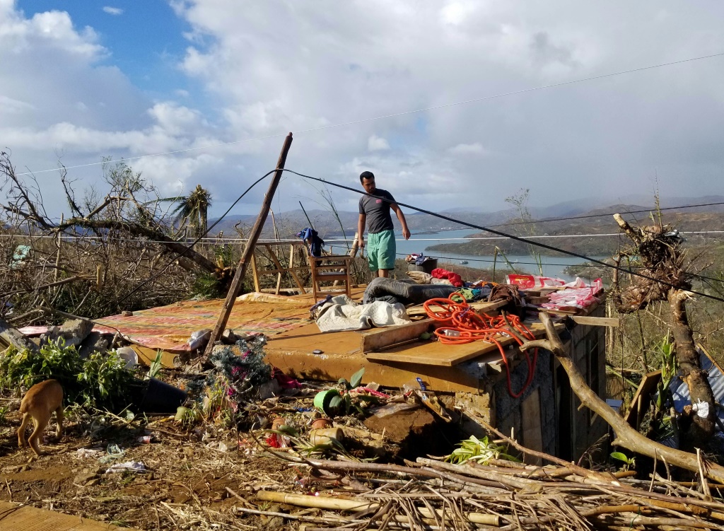 أحد المواطنين واقفا على أنقاض منزله في سان خوسيه على جزيرة ديناغات بعد مرور إعصار راي في الفلبين (ا ف ب)
